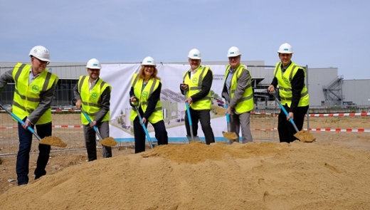 Sechs Personen in Arbeitskleidung setzen den symbolisch ersten Spatenstich zum Bau der Klärschlammverbrennungsanlage.