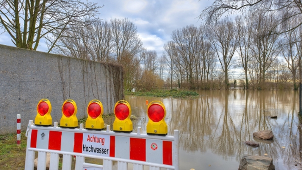 Eine überflutete Aue in Rodenkirchen. Im Vordergrund steht eine Barke, die vor dem Hochwasser warnt.