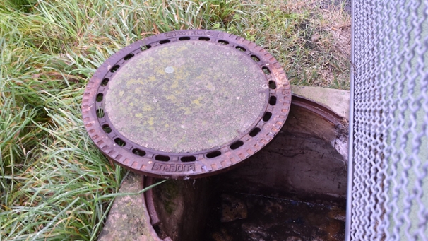 Eine geöffneter Schacht einer Kleinkläranlage.