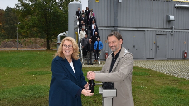 Zwei Personen drehen an einem Stellrad während der Einweihung der Biogasanlage.