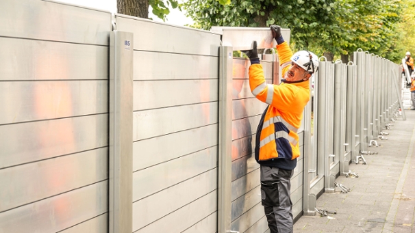 Ein Arbeiter baut eine Hochwasserschutzwand auf.